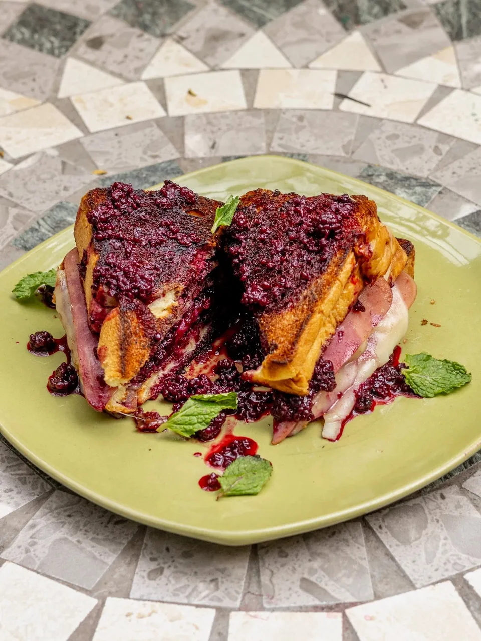 Tostada francesa de moras servida sobre una mesa de mosaico
